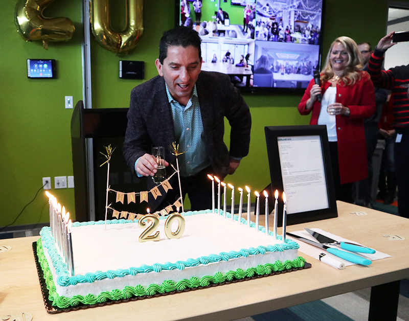 20YRS-faruk2 Photo of Intouch CEO Faruk Capan blowing out candles on a cake.
